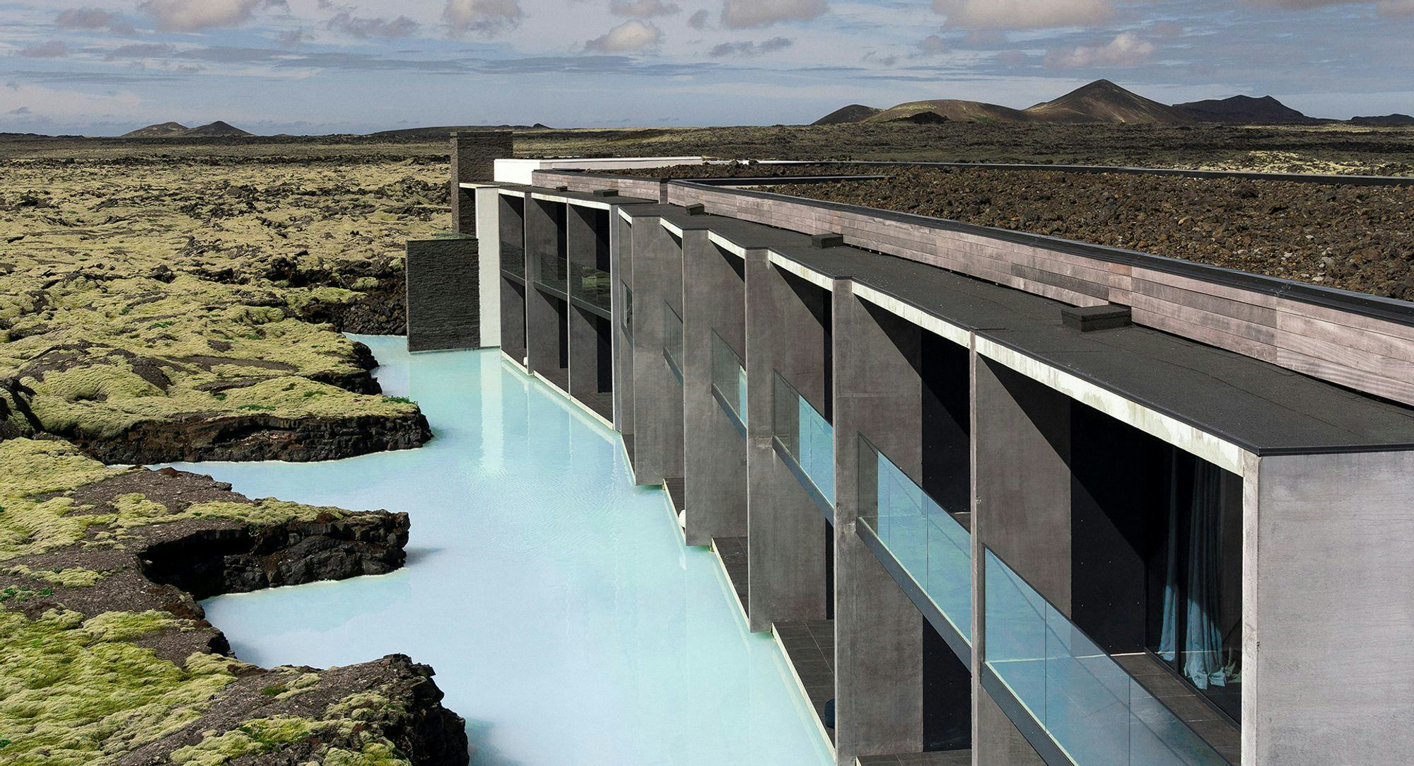 Computer rendering of a modern concrete and wooden building runs a long the right side, blue lagoon in the middle and moss covered lava on the left bank
